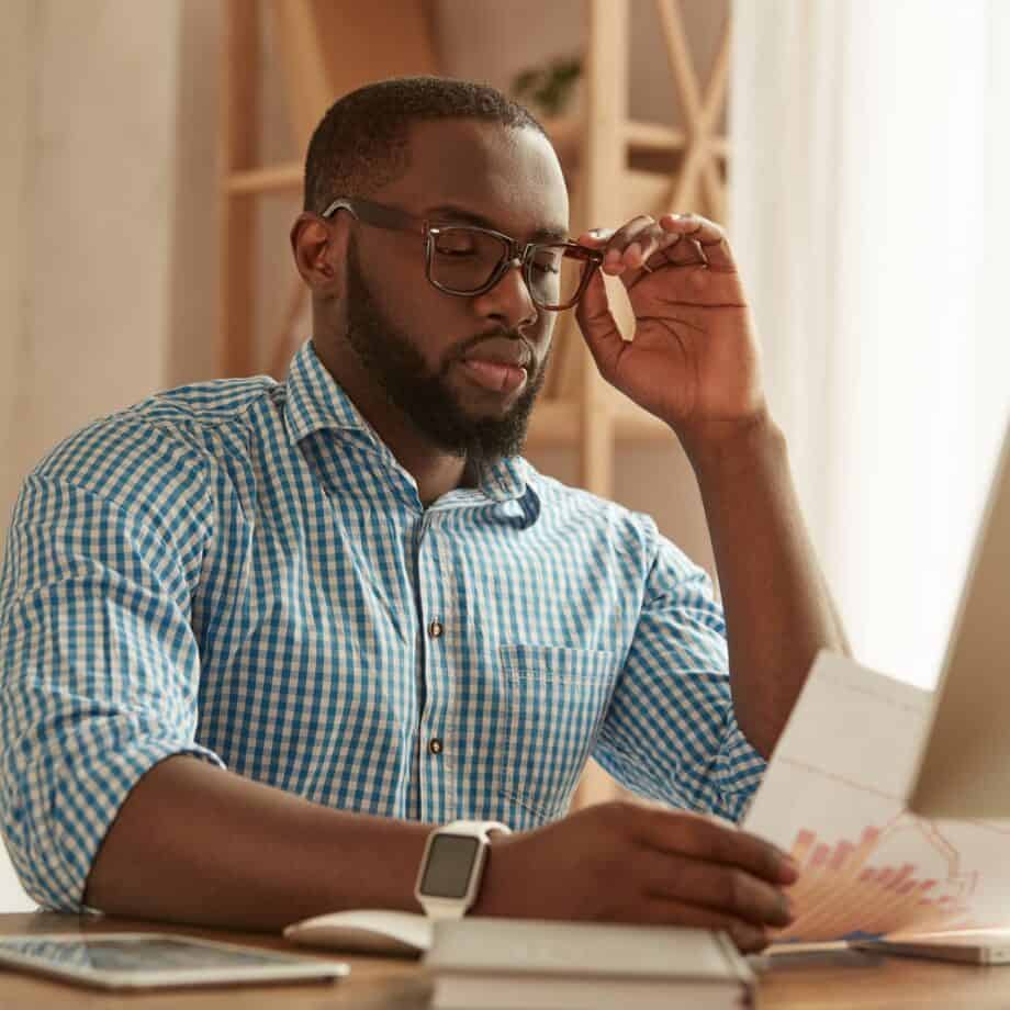 Full concentration. Smart young afro american man in glasses working on the computer while sitting